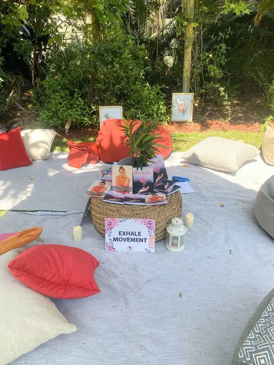 An outdoor Exhale Movement setup with cushions, books and reflection materials