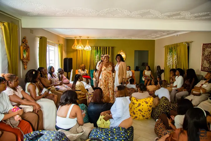 A large group of women gathered closely around facilitators