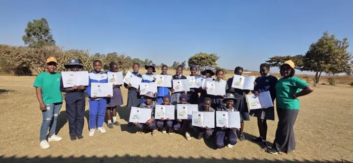 CTT Exhale Circle participants and facilitators displaying completed learning work outdoors